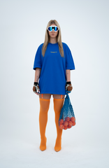 Model in the Haresquare Nautical Blue T-shirt with a Yellow print, styled with Haresquare mini skirt, designer sunglasses, and designer boots in orange – unisex luxury sportswear from Ireland.