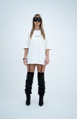 Model in the Haresquare Black T-shirt with a white print, styled with Haresquare mini skirt, designer sunglasses, and designer boots in black – unisex luxury sportswear from Ireland.
