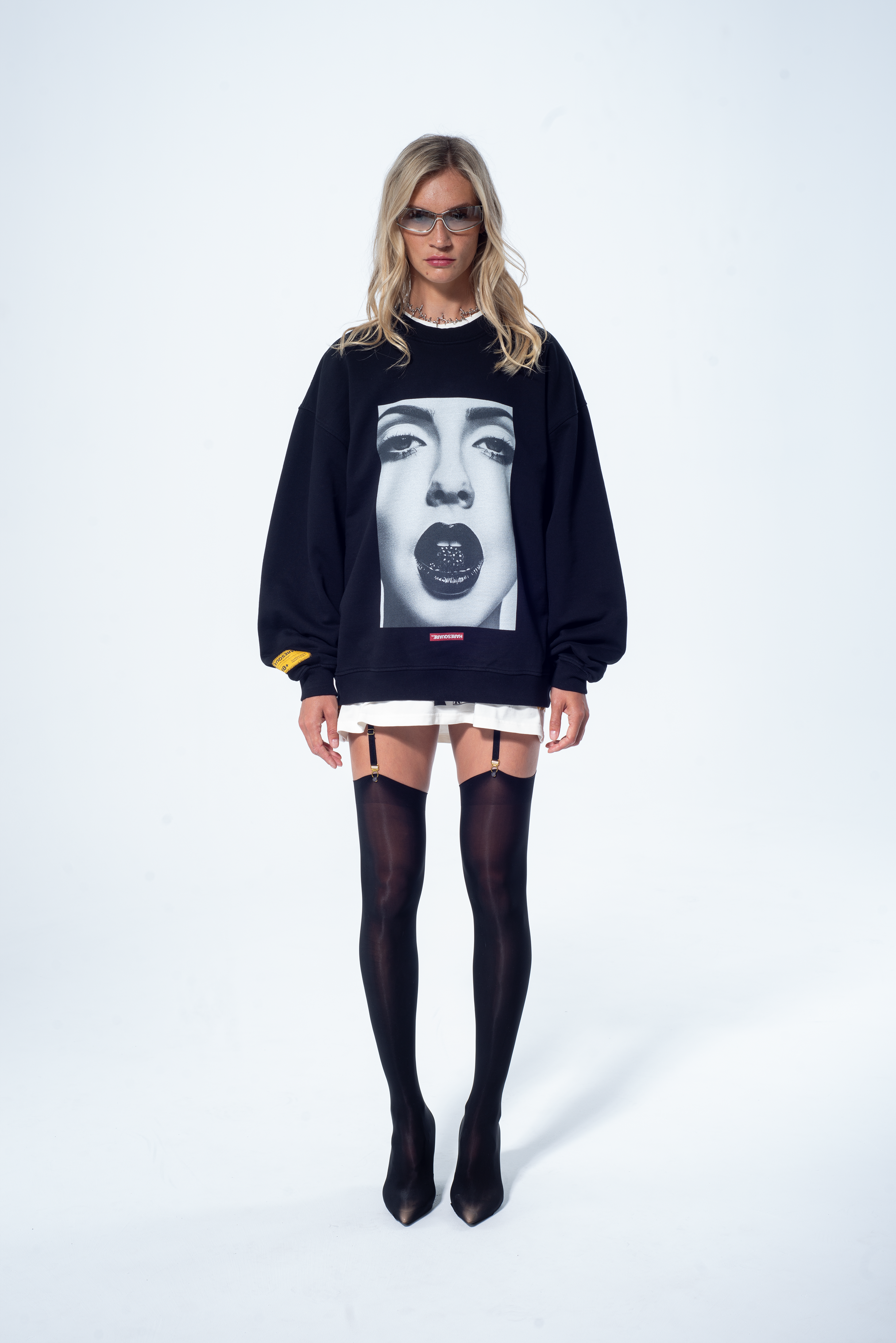 Model in the Haresquare Black sweatshirt with graphic print, styled with Haresquare white skirt – unisex luxury streetwear from Ireland.
