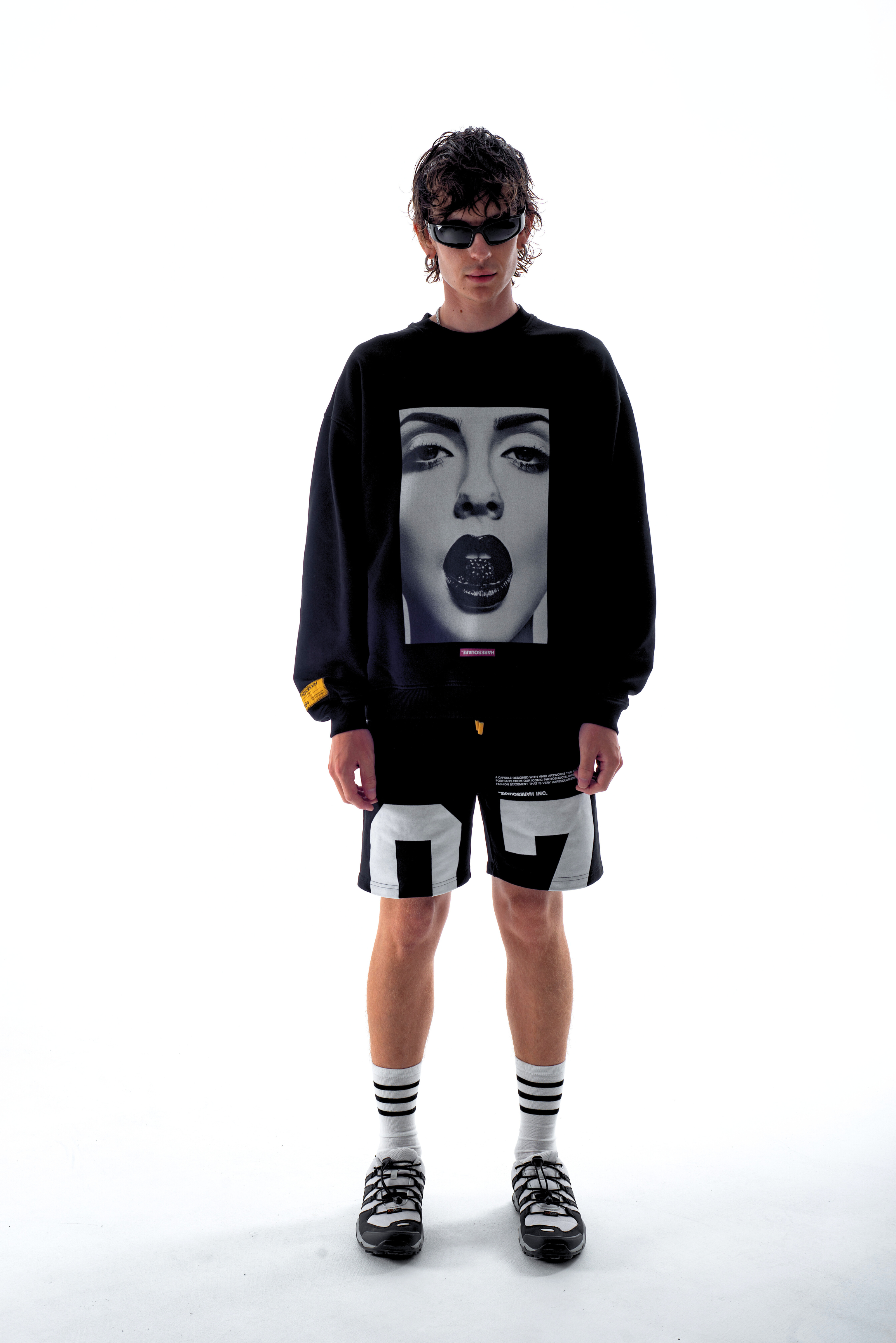 Model in the Haresquare Black sweatshirt with graphic print, styled with Haresquare black shorts – unisex luxury streetwear from Ireland.