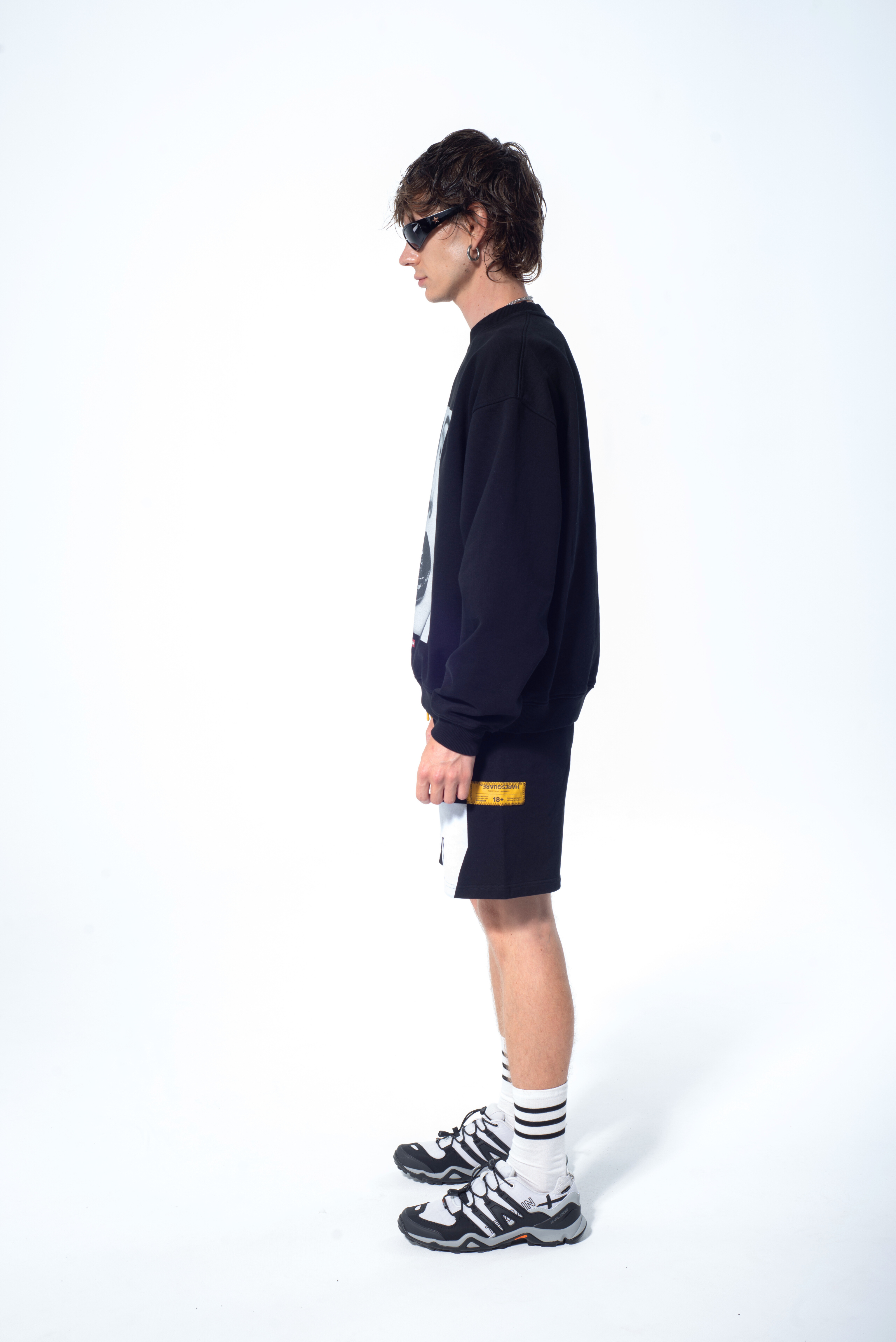 Model in the Haresquare Black sweatshirt with graphic print, styled with Haresquare black shorts – unisex luxury streetwear from Ireland.