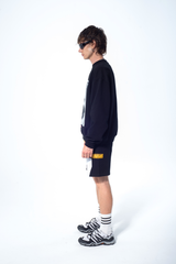 Model in the Haresquare Black sweatshirt with graphic print, styled with Haresquare black shorts – unisex luxury streetwear from Ireland.