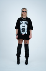 Model in the Haresquare black tshirt with a bold graphic print, styled with Haresquare mini skirt, designer boots in black & Luxury sunglasses – unisex luxury streetwear from Ireland.