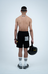 Model in the Haresquare black shorts with a white print, styled with Haresquare luxury sunglasses – unisex luxury streetwear from Ireland.