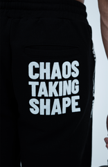 Close-up of Haresquare black shorts with a white print saying Chaos Taking Shape – unisex luxury streetwear from Ireland.