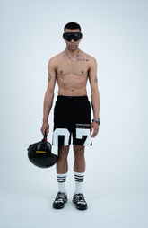 Model in the Haresquare black shorts with a white print, styled with Haresquare luxury sunglasses – unisex luxury streetwear from Ireland.