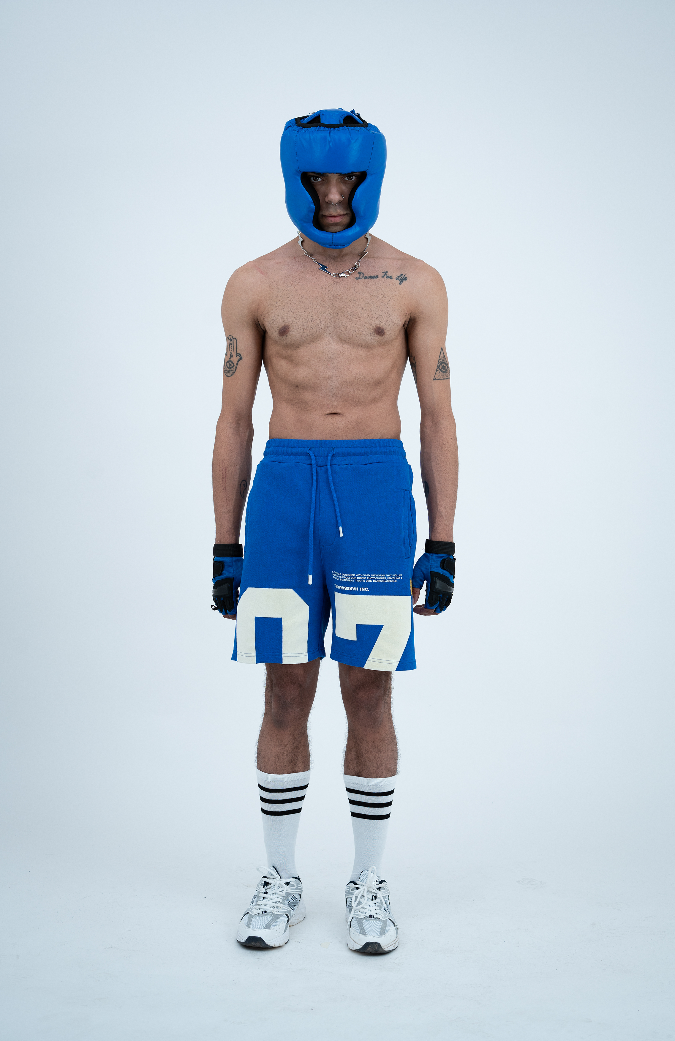 Model in the Haresquare Nautical Blue shorts with a White print, styled with sports accessory – unisex luxury streetwear from Ireland.