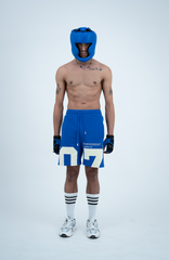 Model in the Haresquare Nautical Blue shorts with a White print, styled with sports accessory – unisex luxury streetwear from Ireland.