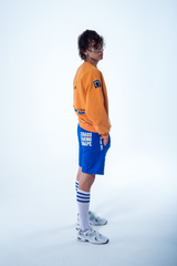 Model in the Haresquare Superhuman Apricot Tan sweatshirt with Blue print, styled with Haresquare Blue shorts – unisex luxury streetwear from Ireland.