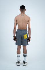 Model in the Haresquare steel grey shorts with a yellow print, styled with Haresquare luxury sunglasses – unisex luxury streetwear from Ireland.