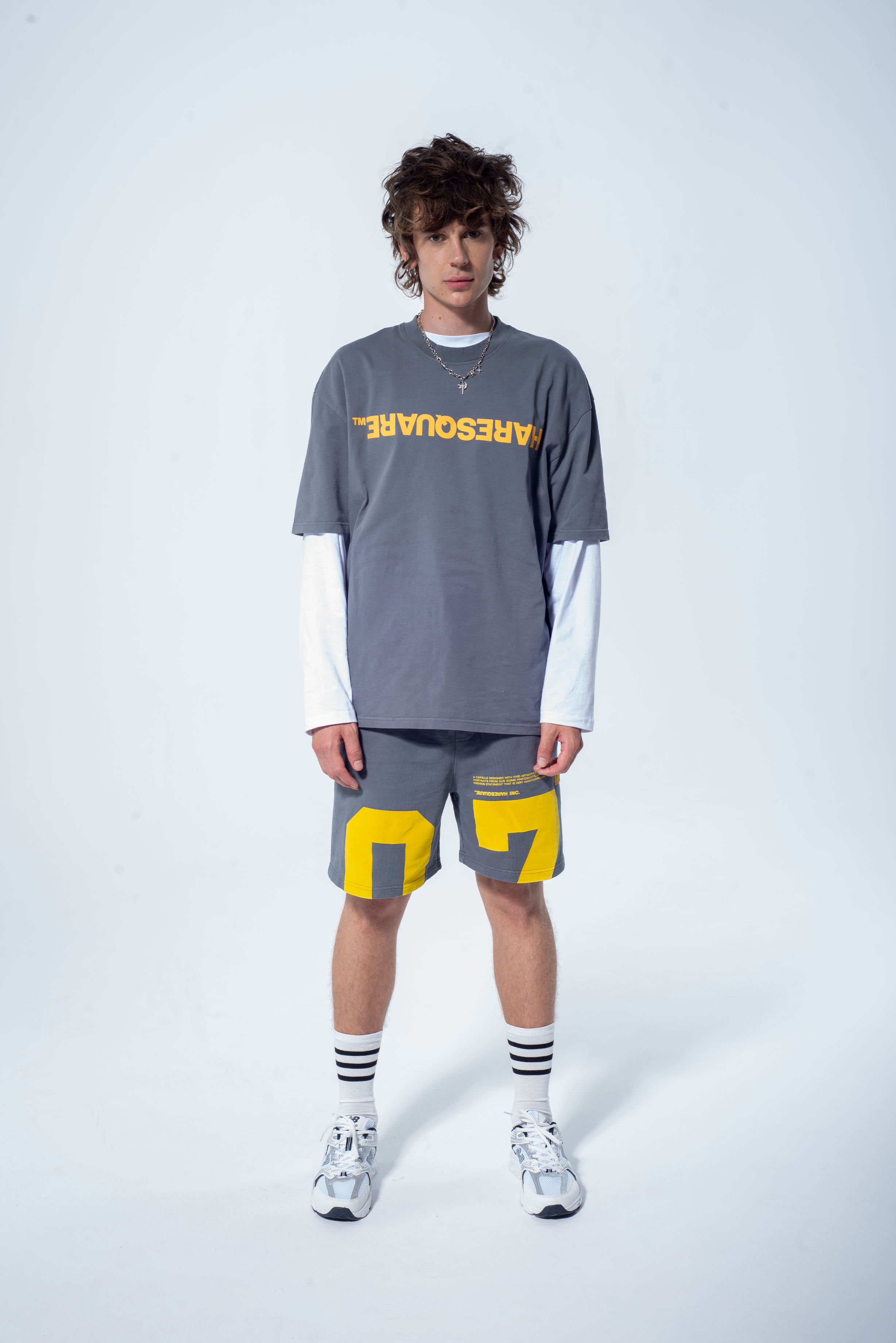 Model in the Haresquare steel grey tshirt with a yellow print, styled with Haresquare shorts in grey – unisex luxury streetwear from Ireland.