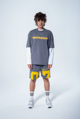 Model in the Haresquare steel grey tshirt with a yellow print, styled with Haresquare shorts in grey – unisex luxury streetwear from Ireland.