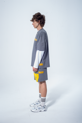 Model in the Haresquare steel grey tshirt with a yellow print, styled with Haresquare shorts in grey – unisex luxury streetwear from Ireland.