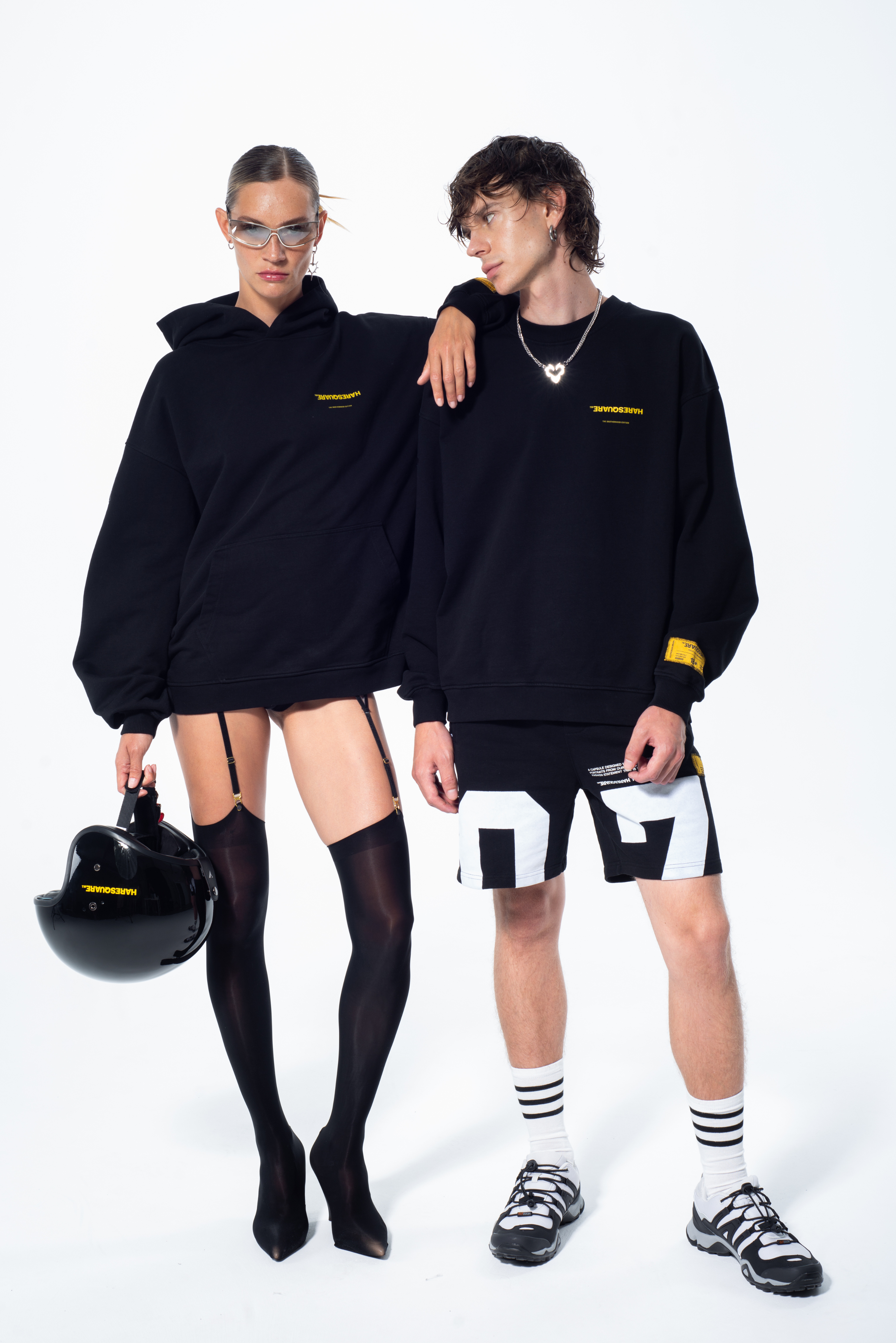 Model in the Haresquare Superhuman black hoodie with yellow print, styled with black helmet – unisex luxury streetwear from Ireland.