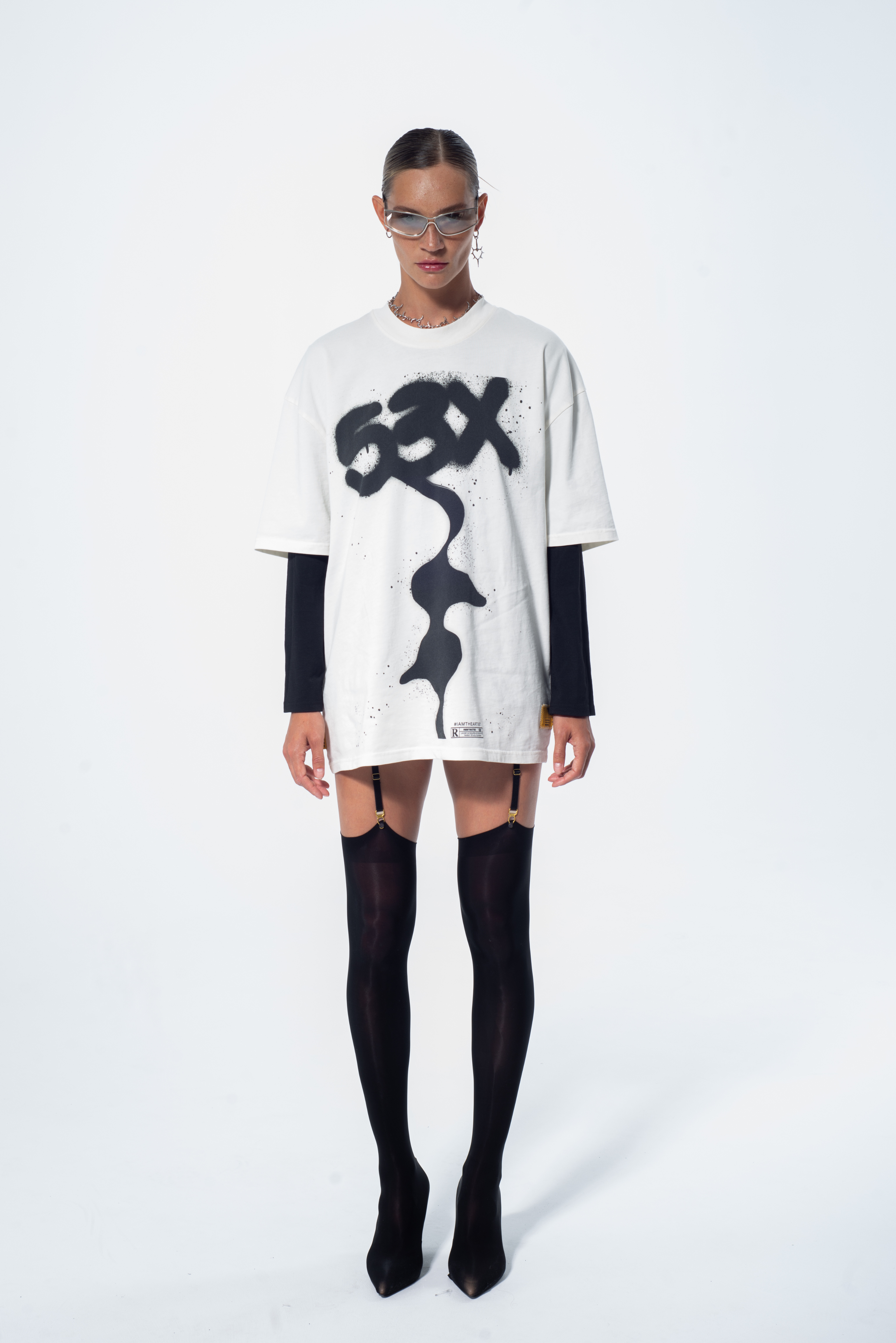 Model in the Haresquare vintage white tshirt with a bold graphic print, styled with Haresquare mini skirt and black designer boots – unisex luxury streetwear from Ireland.