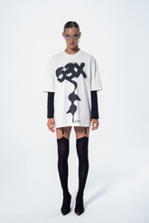 Model in the Haresquare vintage white tshirt with a bold graphic print, styled with Haresquare mini skirt and black designer boots – unisex luxury streetwear from Ireland.