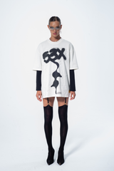 Model in the Haresquare vintage white tshirt with a bold graphic print, styled with Haresquare mini skirt and black designer boots – unisex luxury streetwear from Ireland.