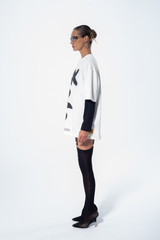 Model in the Haresquare vintage white tshirt with a bold graphic print, styled with Haresquare mini skirt and black designer boots – unisex luxury streetwear from Ireland.