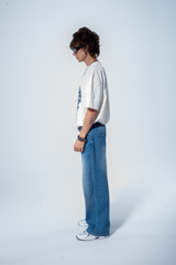 Model in the Haresquare vintage white tshirt with a Skull graphic print, styled with Haresquare blue denim jeans – unisex luxury streetwear from Ireland.