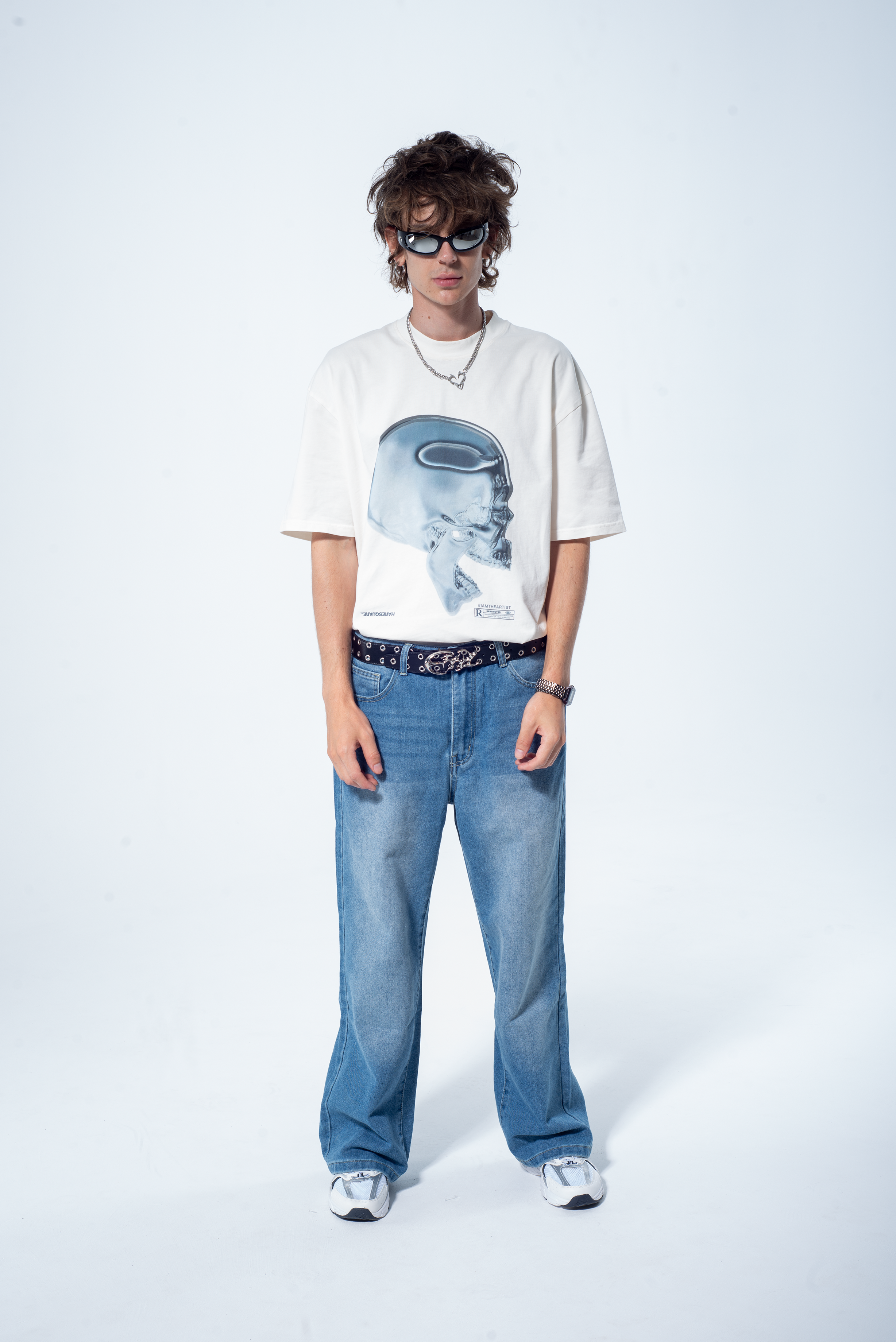Model in the Haresquare vintage white tshirt with a Skull graphic print, styled with Haresquare blue denim jeans – unisex luxury streetwear from Ireland.