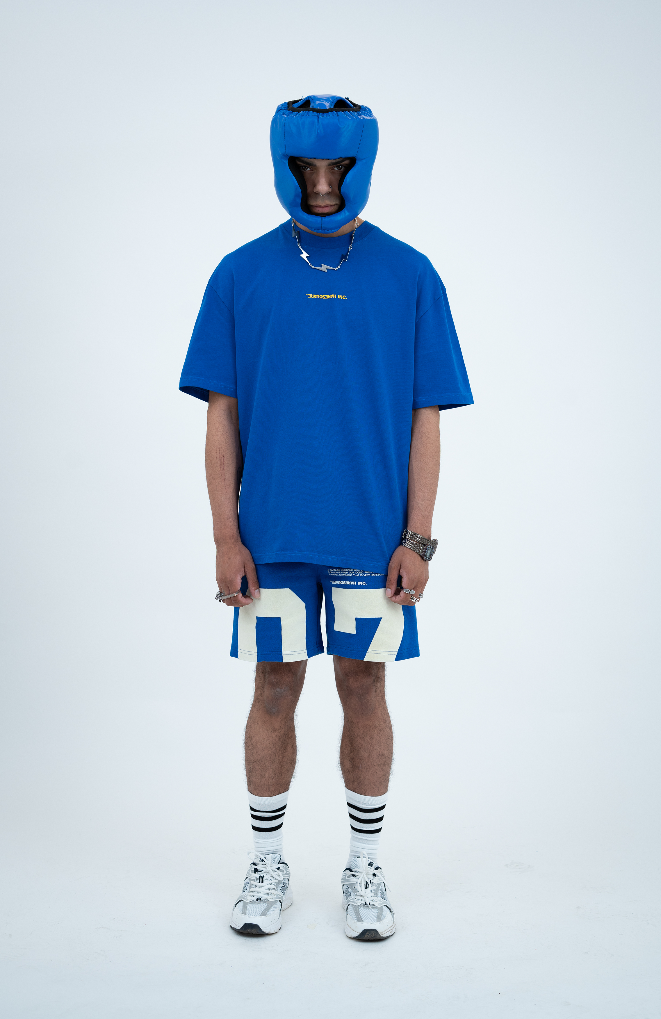 Model in the Haresquare Nautical Blue T-shirt with a Yellow print, styled with Haresquare blue shorts and sports accessory – unisex luxury sportswear from Ireland.