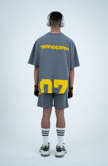 Model in the Haresquare Steey Grey T-shirt with a Yellow print, styled with Haresquare Grey shorts and designer sunglasses – unisex luxury sportswear from Ireland.