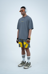 Model in the Haresquare Steey Grey T-shirt with a Yellow print, styled with Haresquare Grey shorts and designer sunglasses – unisex luxury sportswear from Ireland.