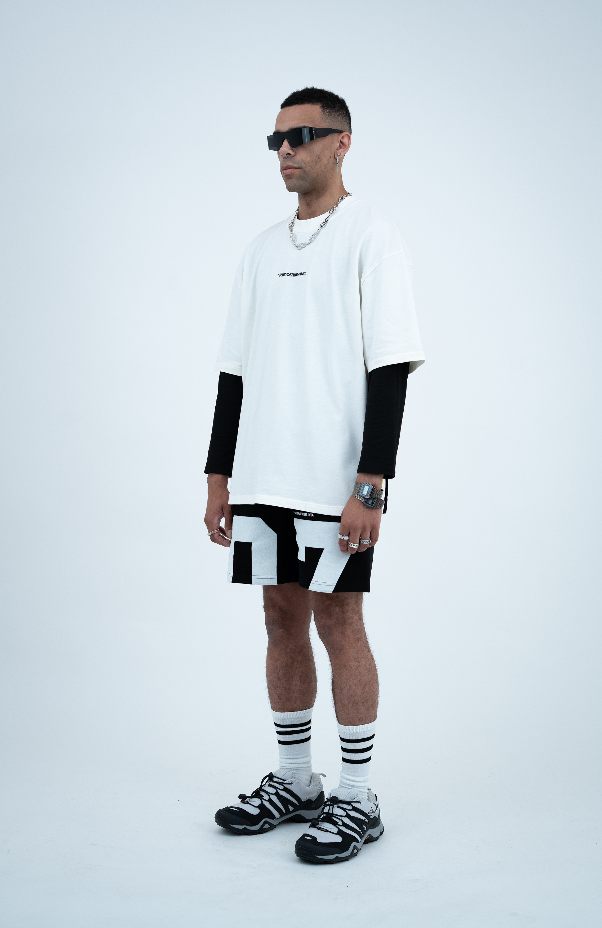 Model in the Haresquare White T-shirt with a Black print, styled with Haresquare Black shorts and designer sunglasses – unisex luxury sportswear from Ireland.