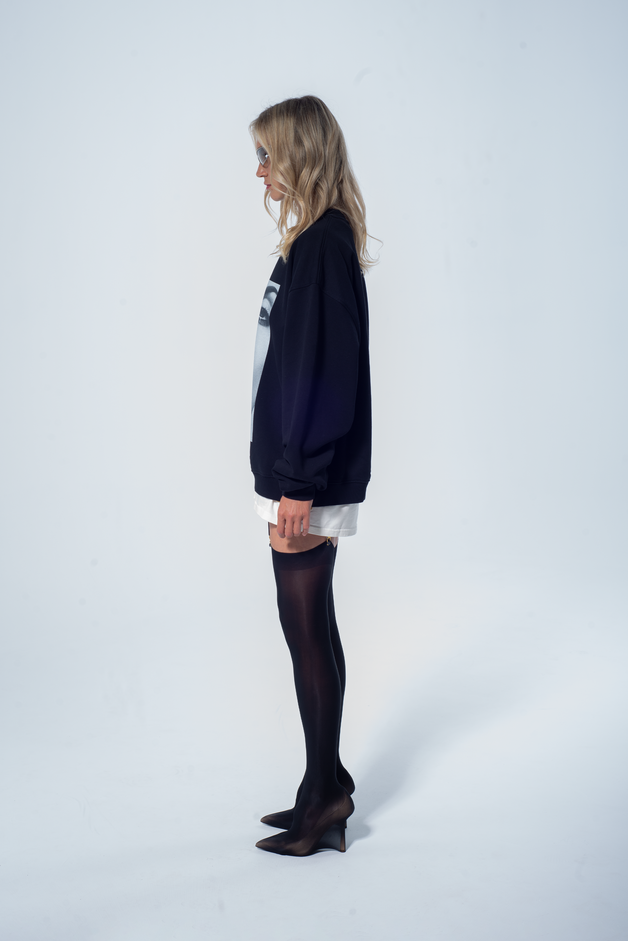 Model in the Haresquare Black sweatshirt with graphic print, styled with Haresquare white skirt – unisex luxury streetwear from Ireland.