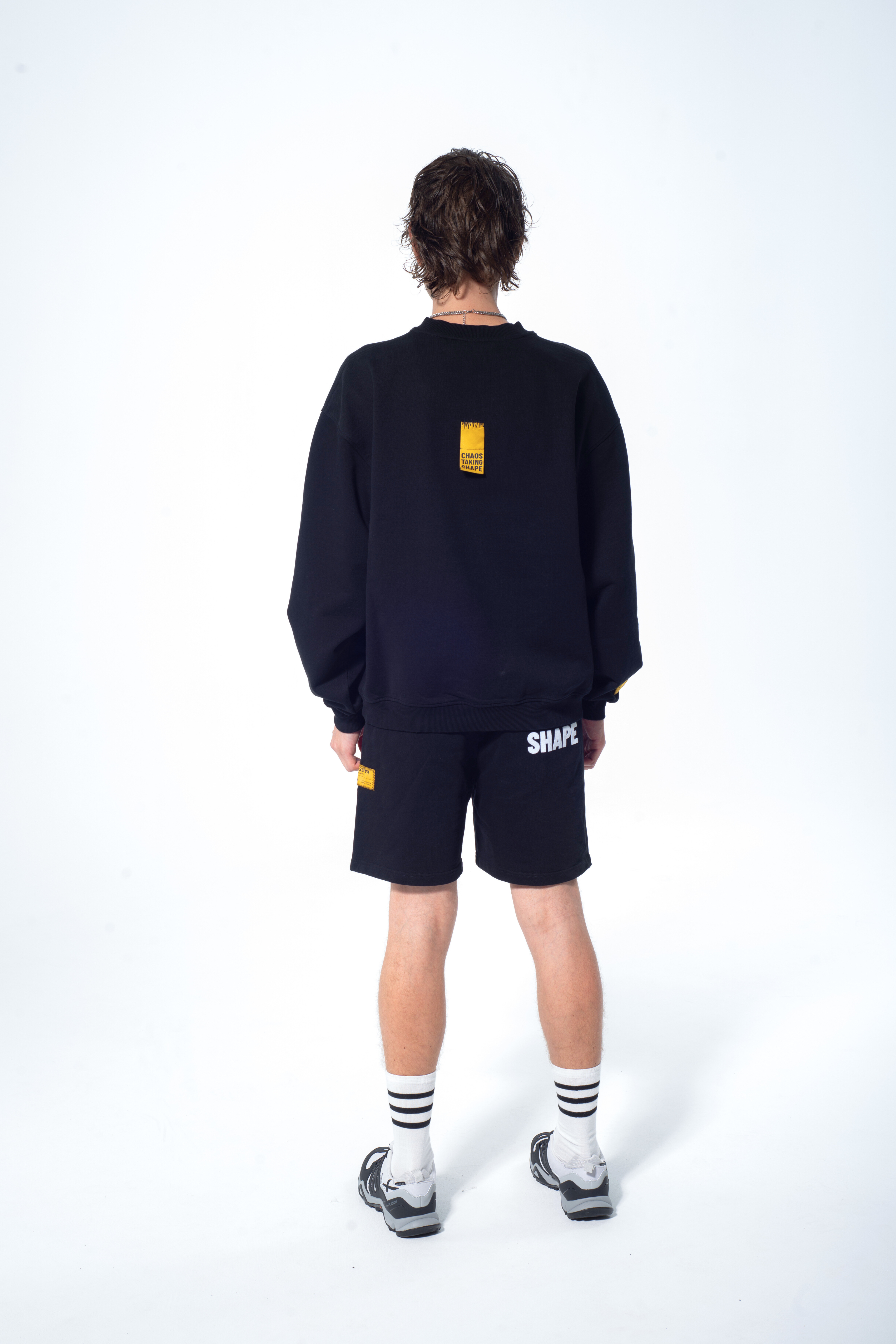 Model in the Haresquare Black sweatshirt with graphic print, styled with Haresquare black shorts – unisex luxury streetwear from Ireland.