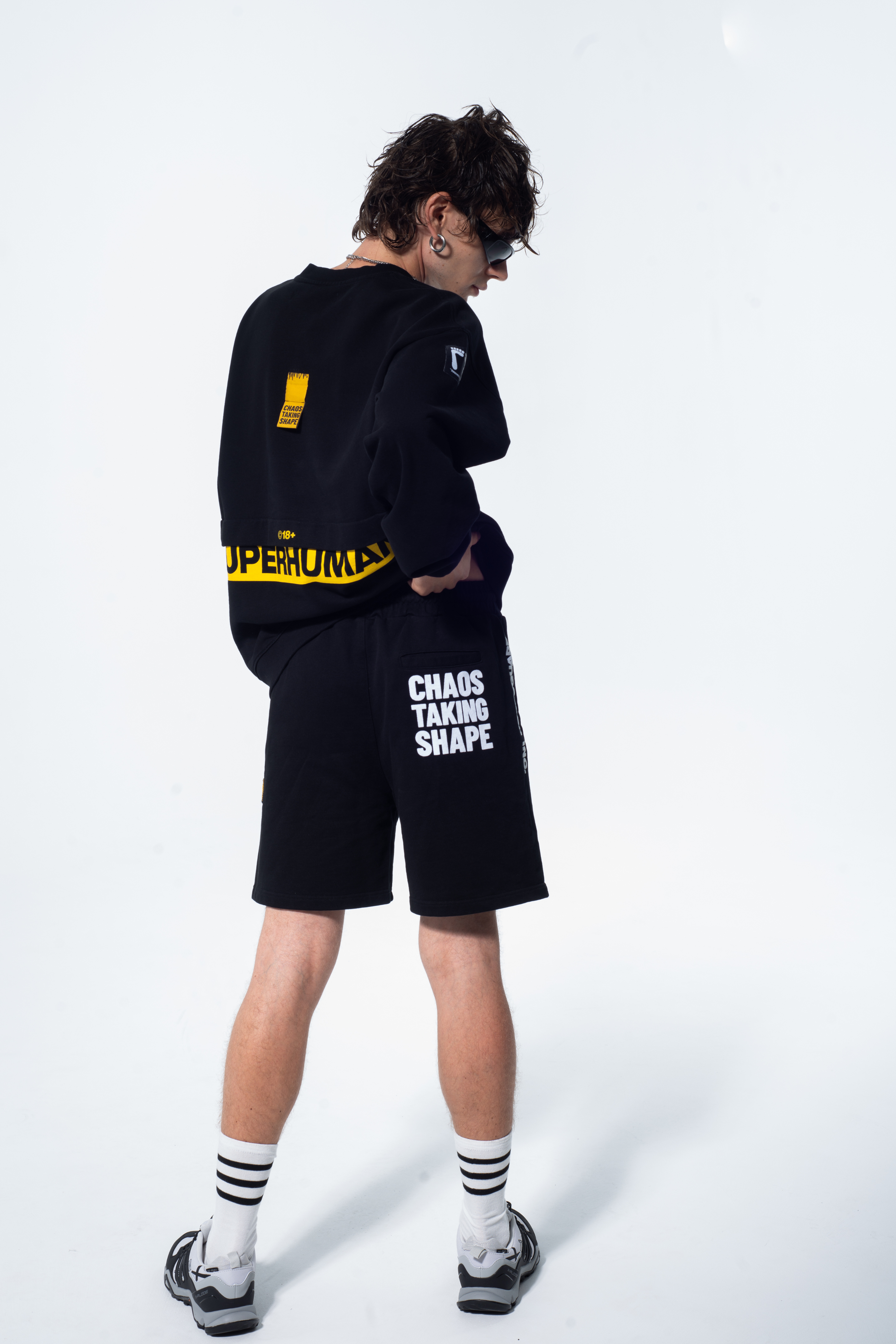 Model in the Haresquare Superhuman black sweatshirt with yellow print, styled with Haresquare black shorts – unisex luxury streetwear from Ireland.