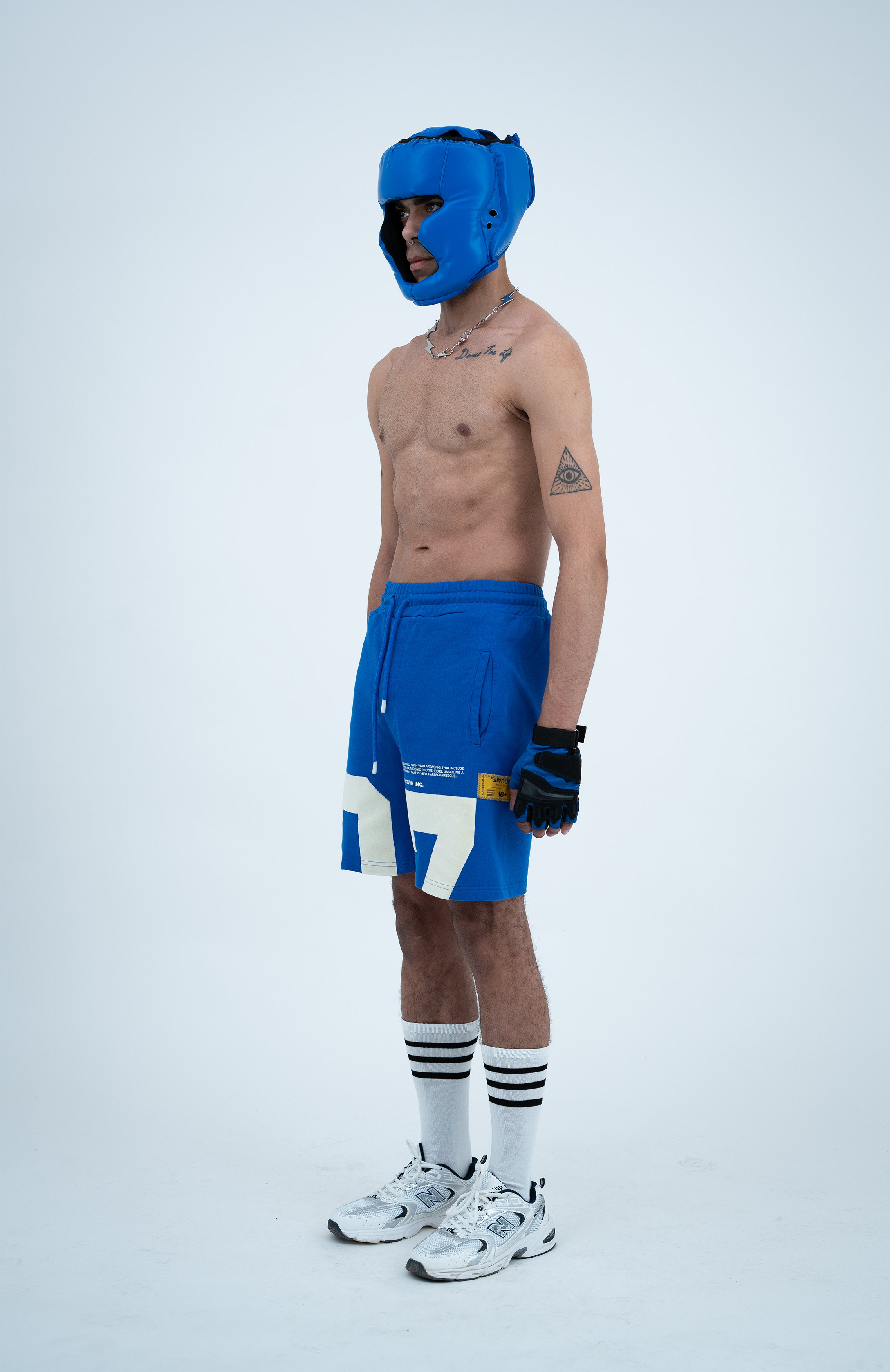 Model in the Haresquare Nautical Blue shorts with a White print, styled with sports accessory – unisex luxury streetwear from Ireland.