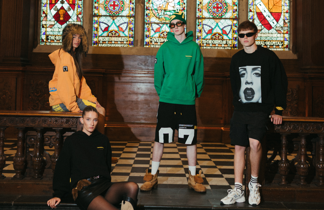 Haresquare unisex luxury streetwear collection featuring hoodies and shorts, photographed in a historic Irish hall with stained glass windows.