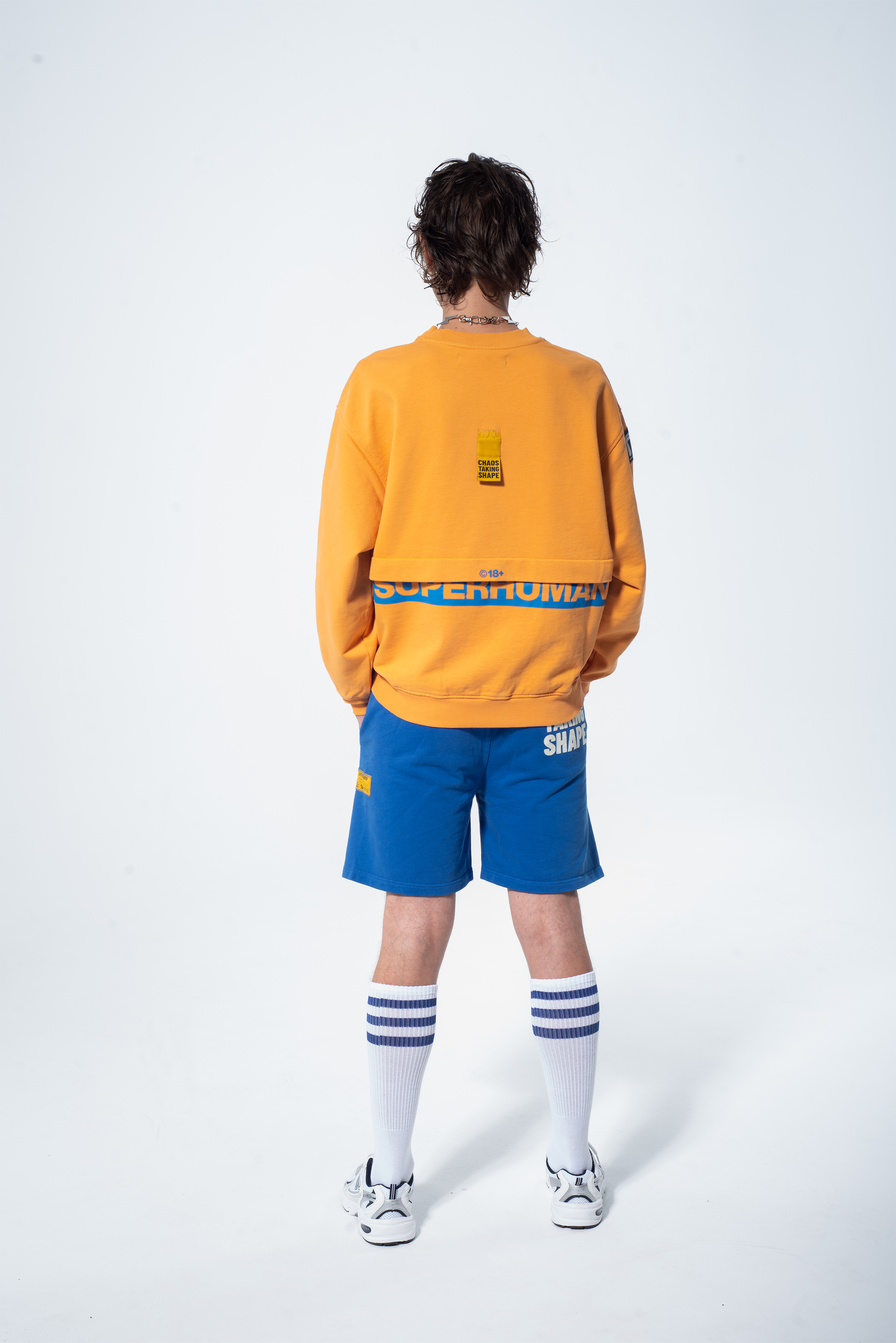 Model in the Haresquare Superhuman Apricot Tan sweatshirt with Blue print, styled with Haresquare Blue shorts – unisex luxury streetwear from Ireland.
