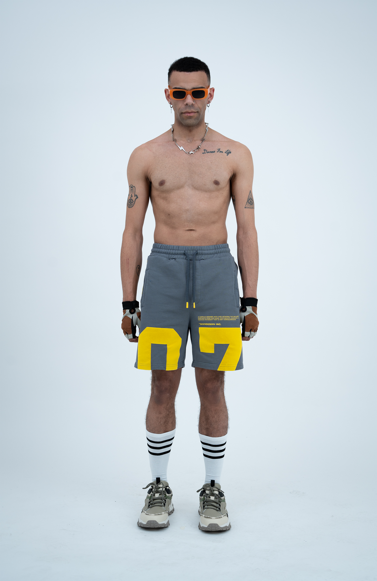 Model in the Haresquare steel grey shorts with a yellow print, styled with Haresquare luxury sunglasses – unisex luxury streetwear from Ireland.