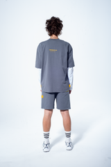 Model in the Haresquare steel grey tshirt with a yellow print, styled with Haresquare shorts in grey – unisex luxury streetwear from Ireland.