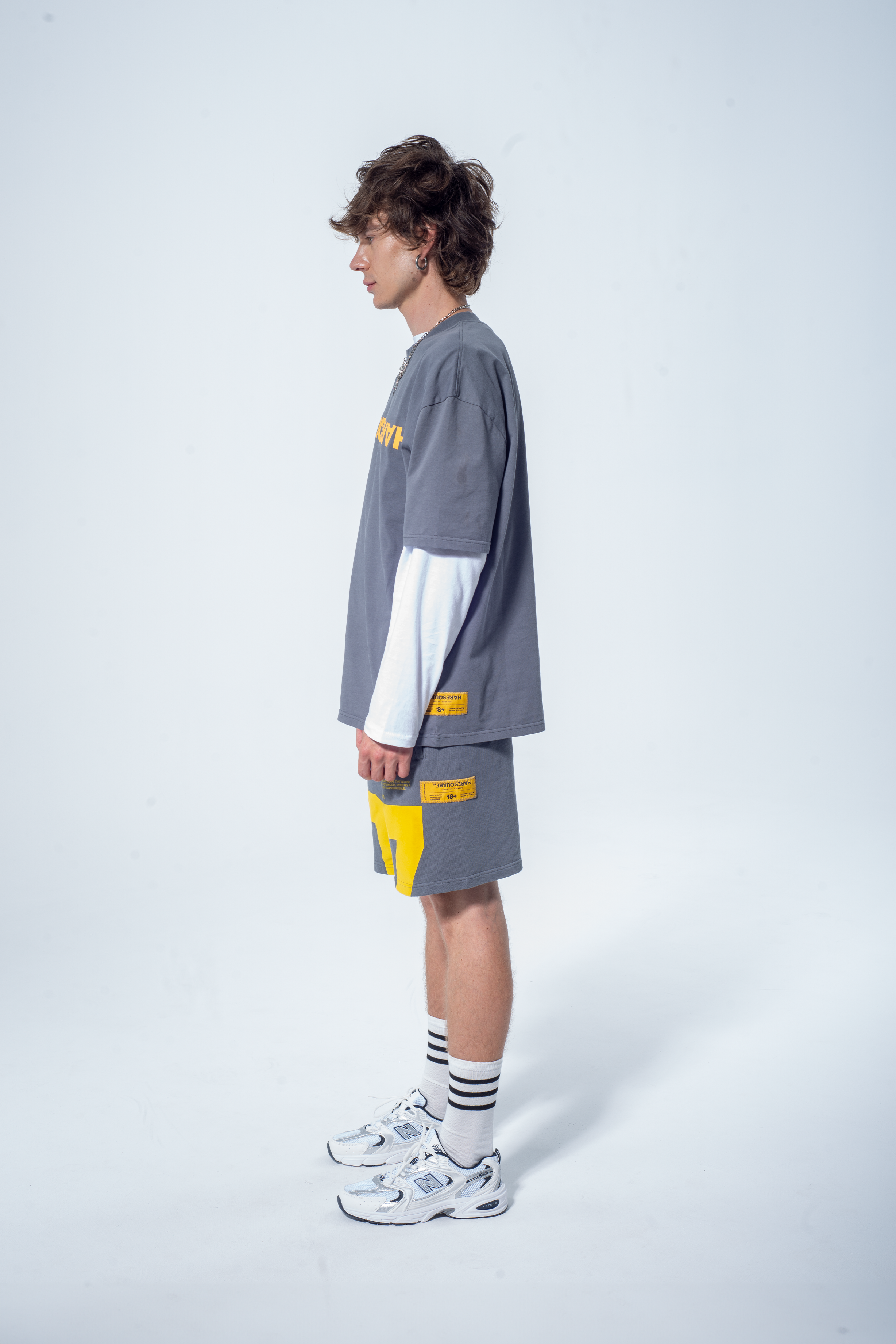 Model in the Haresquare steel grey tshirt with a yellow print, styled with Haresquare shorts in grey – unisex luxury streetwear from Ireland.