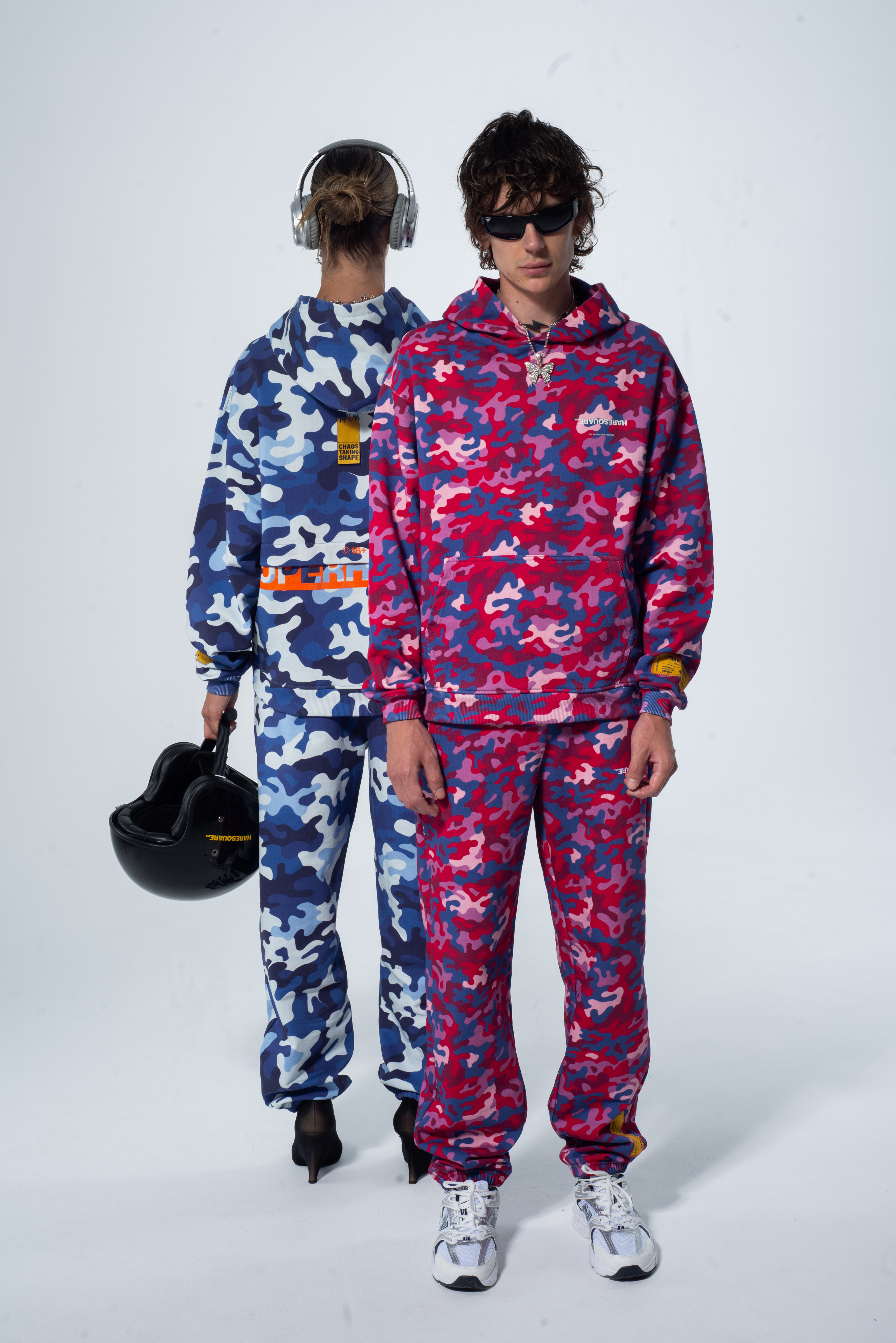 Two people wearing colorful camouflage outfits on a white background – unisex luxury streetwear from Ireland.