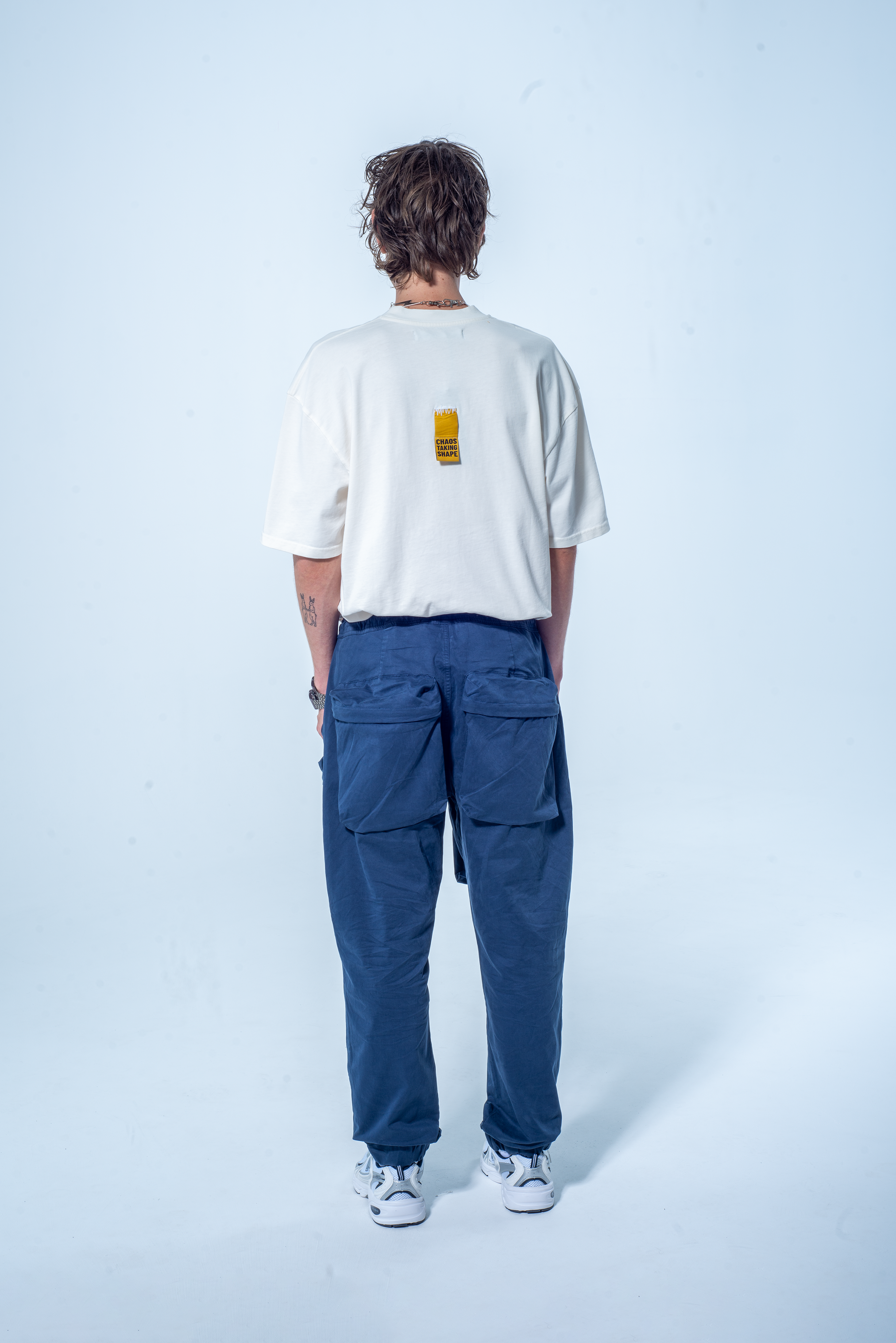 Model in the Haresquare vintage white tshirt with F*CK SOCIETY graphic print in red, styled with Haresquare gray cargo pants – unisex luxury streetwear from Ireland.