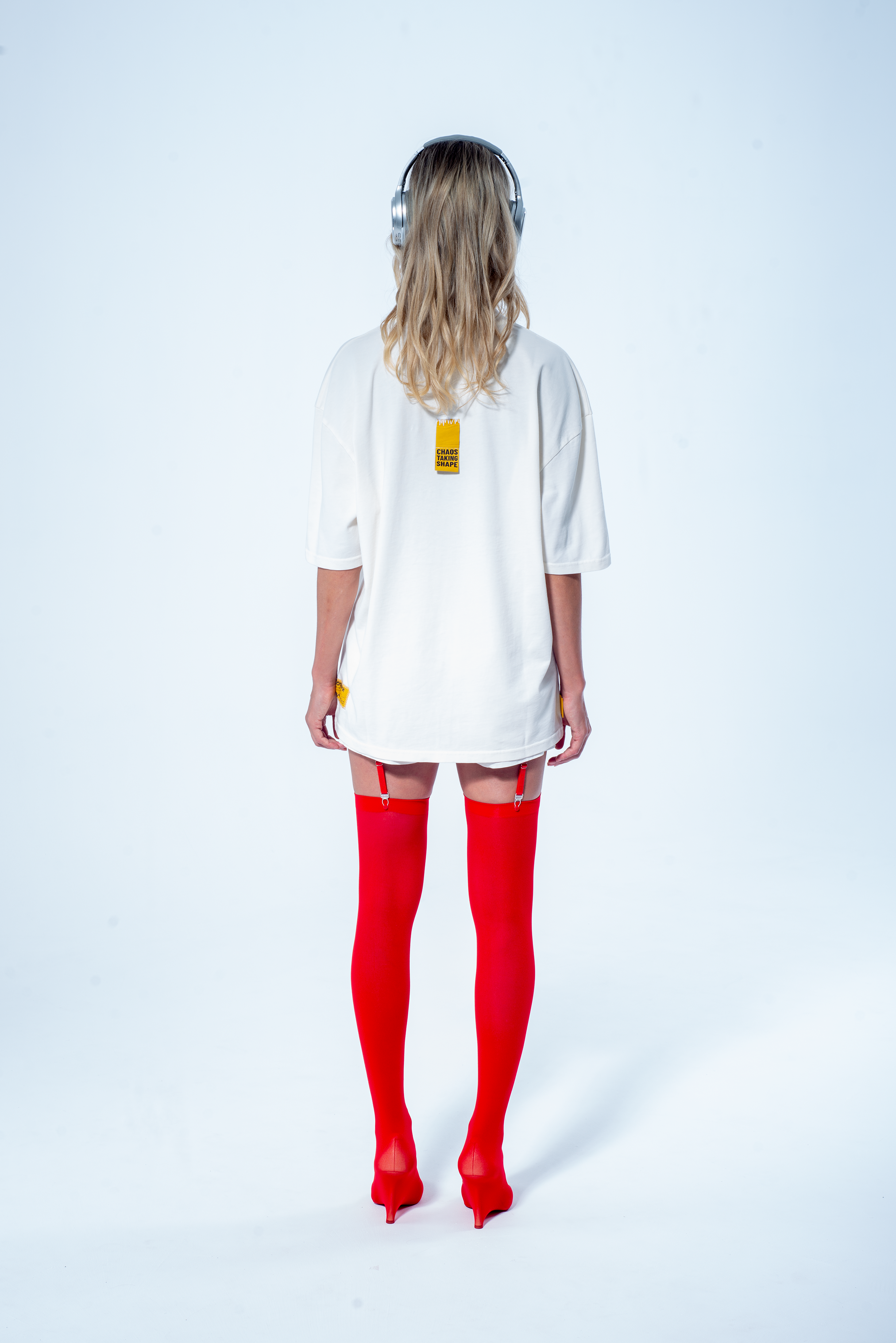 Model in the Haresquare vintage white t-shirt with a Skull graphic print, styled with Haresquare mini skirt and designer boots – unisex luxury streetwear from Ireland.