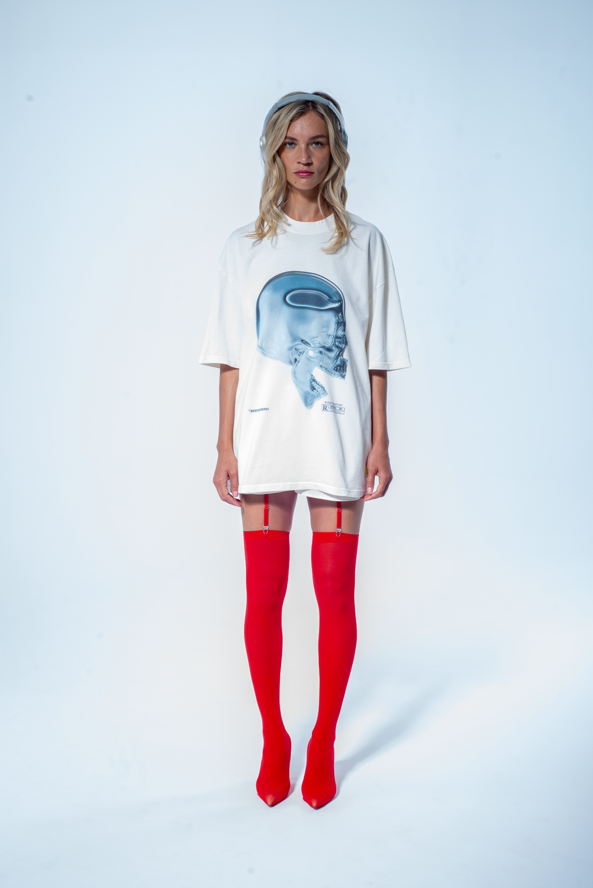 Model in the Haresquare vintage white t-shirt with a Skull graphic print, styled with Haresquare mini skirt and designer boots – unisex luxury streetwear from Ireland.
