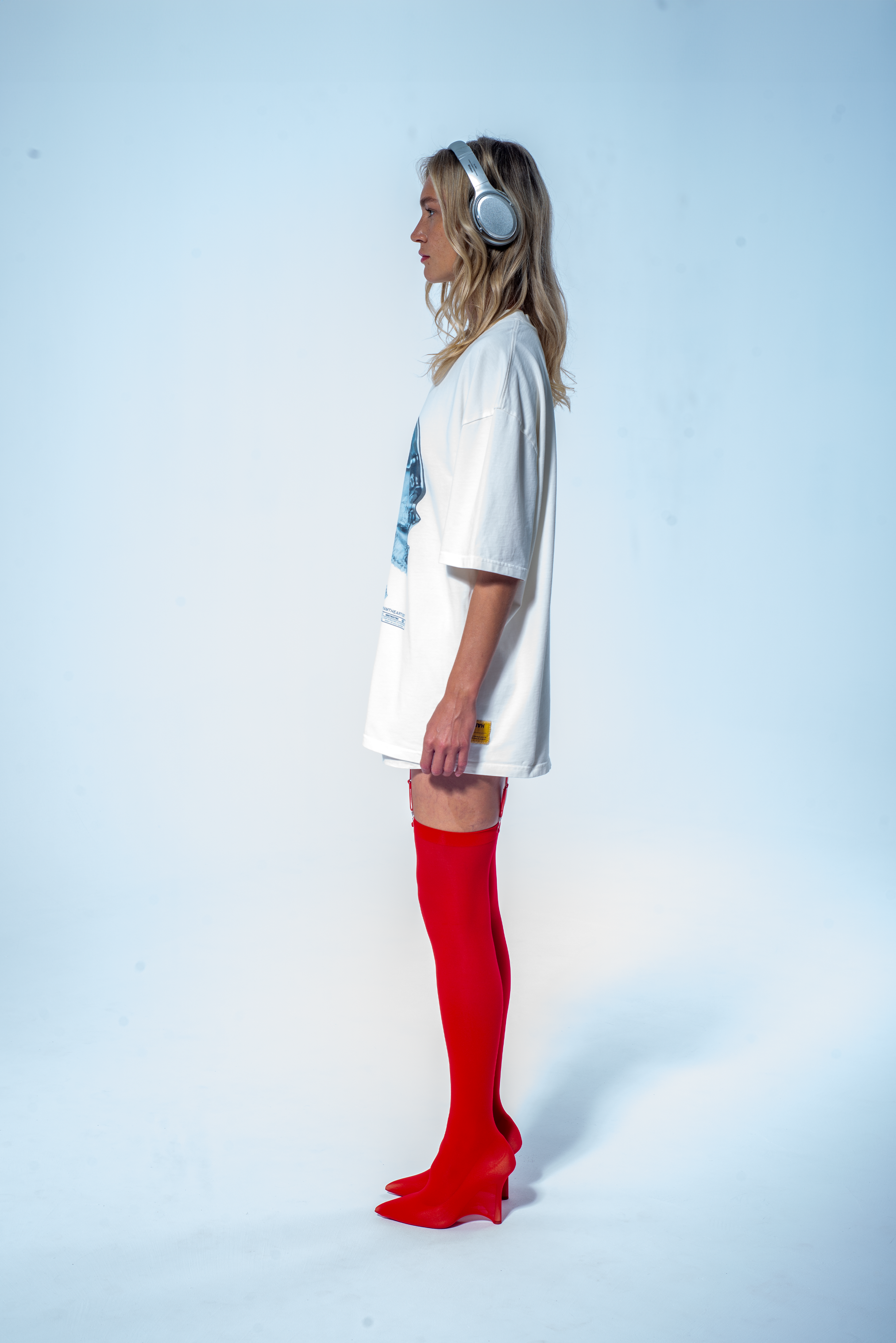 Model in the Haresquare vintage white t-shirt with a Skull graphic print, styled with Haresquare mini skirt and designer boots – unisex luxury streetwear from Ireland.